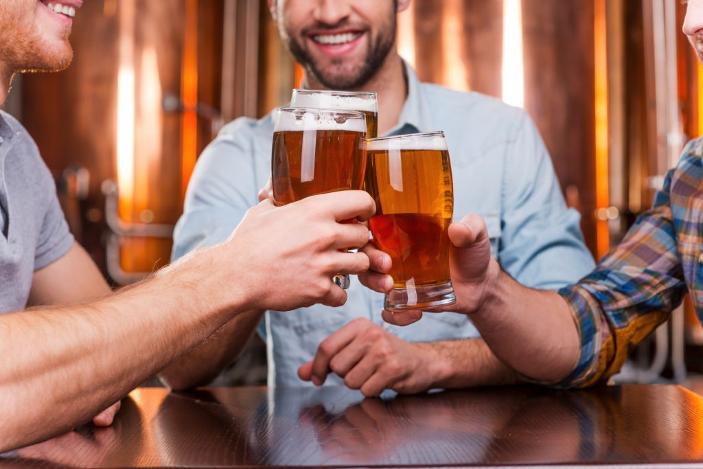 10674940-old-friends-meeting-close-up-of-three-happy-young-men-in-casual-wear-toasting-with-beer-while-sitting-in-beer-pub-together